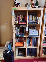 Front view of IKEA cubby storage case filled with books and a few decorative items on top.