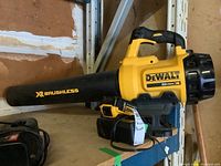 Overall view of DeWalt blower, battery inserted and charger on shelf