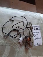 Photo showing the ring, necklace, and pin together on a surface with lot tag