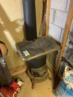 Full view of cast iron stove installed in basement corner