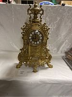 Front-facing full view of gilt bronze clock on table