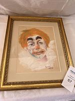 Front view of framed clown chalk art showing orange-haired clown face with white ruffled collar in detailed golden frame.