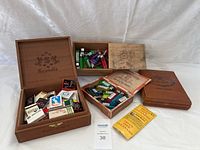 Three wooden boxes, one branded 'Scandia,' containing multiple lighters and matchbooks.