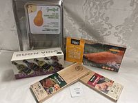 Photo showing baking trays, wood smoking planks labeled cedar and cherry, a package of smoked sockeye salmon, and a boxed set of Buon Vino olive oils in small bottles