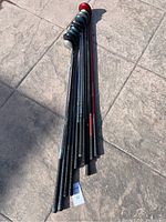 Full view of 10 golf clubs laid on ground showing the shafts and grips