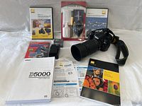 Overview of camera, lens, cleaning kit, DVDs, manuals, charger, batteries, memory card