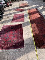 All five rugs laid out on driveway showing sizes and patterns