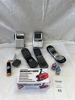 Full lot view with all phones, emergency radio, and chargers visible on white fabric background.