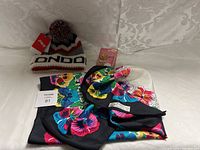 Photo showing knitted hat, two floral scarves, and table light accessory.