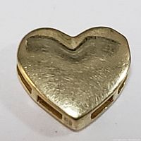 Front view of 10K yellow gold heart shaped pendant showing smooth surface and slight wear.