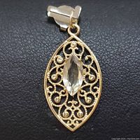 Front view of the 14K yellow gold pendant highlighting the marquise-cut Zultanite and ornate filigree design.