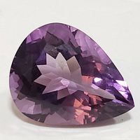 Front angled view of pear-shaped faceted amethyst gemstone showing purple color and polish.