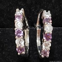 Pair of sterling silver hoop earrings with alternating created alexandrite and white stones in a secure clasp design.