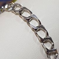 Close-up of the bracelet chain links showing angular faceted design and polish.