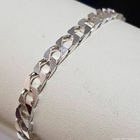 Close-up photo showing a section of the sterling silver curb link bracelet with polished flat links.