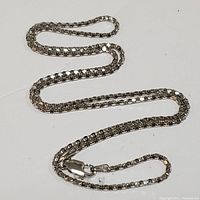 Photo of the full sterling silver chain necklace laid out to show length and link style.
