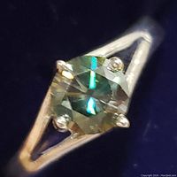 Close-up photo of the sterling silver ring with round cut moissanite stone showing setting and facets.