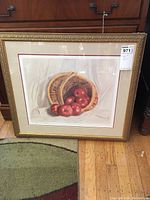 Full view of framed print showing still life of apples and basket in gold frame.
