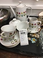 Photo showing the teapot, sugar bowl with lid, creamer pitcher, cups and saucers with floral pattern along with a MaxSold lot tag and handwritten note.