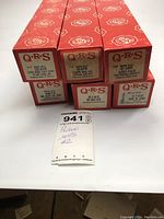 Six QRS branded red boxes containing piano rolls stacked in two rows, clearly showing labels with titles and product numbers.