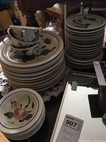 Stack of various china plates and cups with floral patterns in Redwing set. Pieces appear heavy and thick with visible wear.