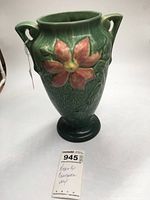 Full view of the green Roseville pottery vase with raised poinsettia flower and two small handles
