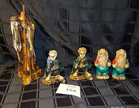 All five fantasy figurines displayed on black grid fabric background showing wizard, two smaller characters, and two dwarfs