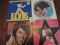 Photo showing the full lot of four Elvis vinyl LP records arranged flat on table, highlighting front album covers for identification.