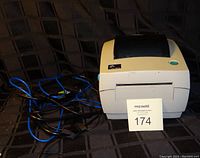 Front and side view of Zebra LP2844 label printer with attached cables.