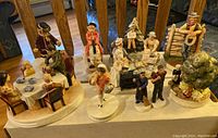 Wide view of 10 Sebastian Miniature porcelain figurines including family scenes, children, and Americana themes.