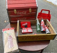 Yellow wooden Coca-Cola crate repurposed as a treasure chest with metal clasps, measuring 18.5x13.25x12 inches, displayed with other collectible Coca-Cola items.