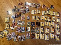 Wide view of over 100 football cards laid out including the two silver card sets with yellow and silver background cards.