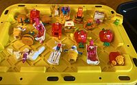 Photo showing 20 McDonald's 1990 Happy Meal Transformer toys arranged on a yellow surface, featuring a variety of food items like fries, nuggets, Big Mac, milkshakes, ice cream cones.