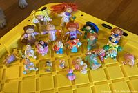 Overview photo showing all 22 miniature Cabbage Patch Kid dolls on a yellow tray, various colors and styles visible.