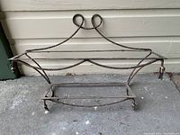 Front view of antique iron window flower box showing twisted coil iron frame and loops at top
