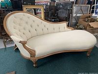 Full side view of cream tufted fainting couch on casters
