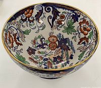 Close-up angled view showing inner floral pattern and gold rim of the footed bowl.