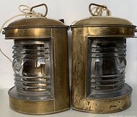 Two lamps side by side showing front view of brass housing and ribbed glass lenses on neutral background