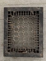 Top view showing the entire rectangular antique iron floor grate with geometric pattern and frame.