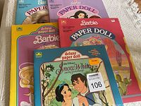 Five vintage uncut paper doll books stacked with Barbie and Snow White themes