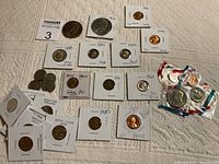 Variety of coins displayed on towel surface with some in holders and rolls