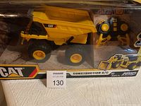 Front view of CAT remote control construction dump truck in box with remote controller visible