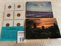 Four coin sets laid out on a white cloth surface, showing packaging of 1999 Delaware Coin Collector Set, 2008 Denver US Mint Set, US Treasury Commemorative Medallion set with six medallions mounted individually, and a red holder of United States Mint Uncirculated Coin Set.