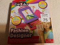 Photo of Cra-Z-Art Fashion Designer kit box showing product imagery and text, with visible corner damage on box but stating contents are undamaged.