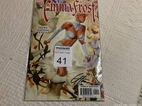Front cover of the Emma Frost comic book with protective plastic, showing signature and cover art.