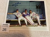 Signed photo of three New York Mets players sitting on dugout bench, with Lenny Dykstra's autograph in upper left corner.