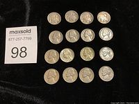 Top down view showing 16 assorted nickels dated from 1934 to 1949, displayed on a black background.