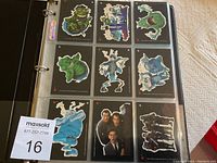Binder page showing 9 Teenage Mutant Ninja Turtles II black background character stickers including turtles and enemies.