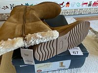 Pair of tan faux suede women's boots size 10 with faux fur lining, displayed on the damaged original shoe box showing the ridged sole and side zipper.
