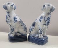 Pair of white ceramic Labrador retriever dog bookends with blue floral chinoiserie designs, sitting on blue bases